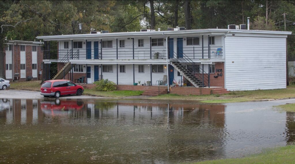 Toxic water flows up to an apartment building at 19 Kennedy Drive in Craddock during high tide and heavy rains. The owner's daughters said she played in the water growing up and her mother has cancer. Credit: Michael DiBari