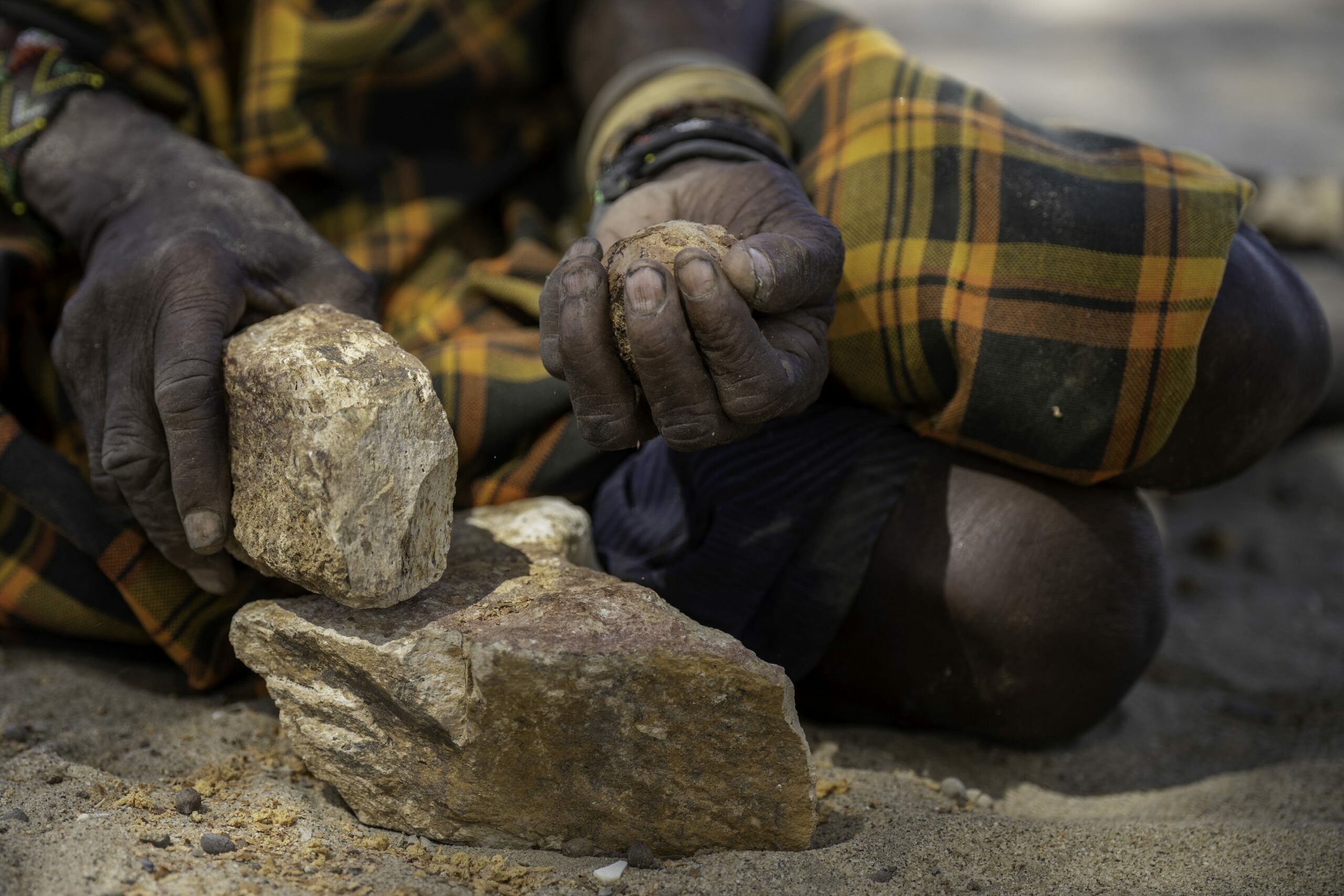 Women use rocks to pound doum palms for a midday snack in Kangichok, Turkana County, Kenya. Credit: Larry Price