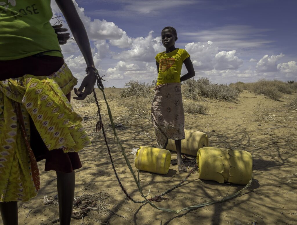 These women walked nearly 10 miles dragging plastic containers of water scavenged from desert wells in Turkana County, Kenya. Credit: Larry Price